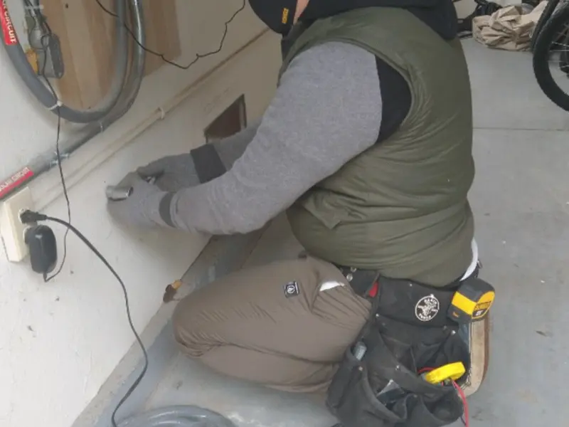 Electrician performing outlet wiring in a Glasgow garage